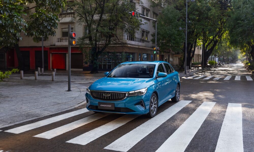 a front three-quarters shot of a blue Geely Emgrand driven on the road