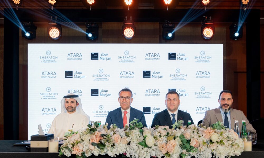 Four executives at ATARA Development, Sheraton, and Marjan partnership signing ceremony with floral arrangements and branded backdrop wall.