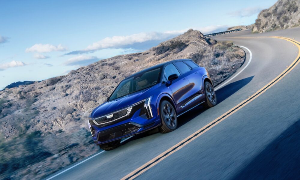 a side three-quarter shot of a Cadillac Optiq driven on a winding mountain road