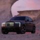 A front three-quarter shot of the Rolls-Royce Black Badge Cullinan Series II Desert Sunset parked in the desert.