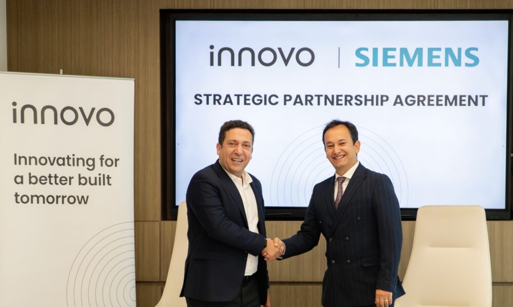 Two executives from Innovo and Siemens shake hands during a strategic partnership agreement signing ceremony in Dubai.