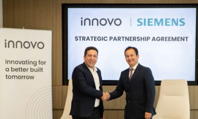 Two executives from Innovo and Siemens shake hands during a strategic partnership agreement signing ceremony in Dubai.