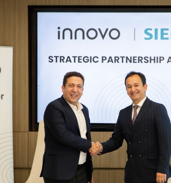 Two executives from Innovo and Siemens shake hands during a strategic partnership agreement signing ceremony in Dubai.