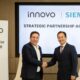 Two executives from Innovo and Siemens shake hands during a strategic partnership agreement signing ceremony in Dubai.