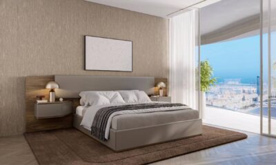 Modern master bedroom with contemporary Pininfarina furniture, textured wall panels, panoramic city views, and neutral color scheme in luxury Dubai apartment.
