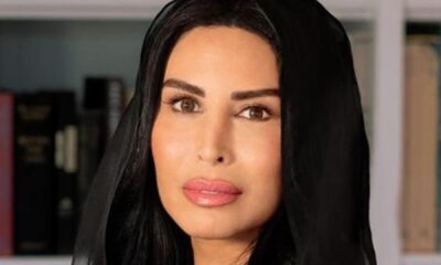 Rasha Al Mubarak, Founder and Chairwoman of Music Nation, portrait in black abaya against modern office interior background.