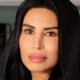 Rasha Al Mubarak, Founder and Chairwoman of Music Nation, portrait in black abaya against modern office interior background.