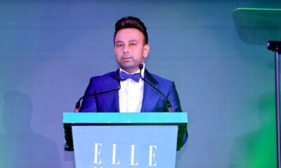 Ravi Bhirani, Managing Director of ANAX Developments, speaking at ELLE Residences Dubai Islands launch event in formal blue tuxedo at podium.