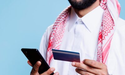 arab-hands-holding-credit-card-phone for ADIB