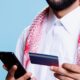 arab-hands-holding-credit-card-phone for ADIB