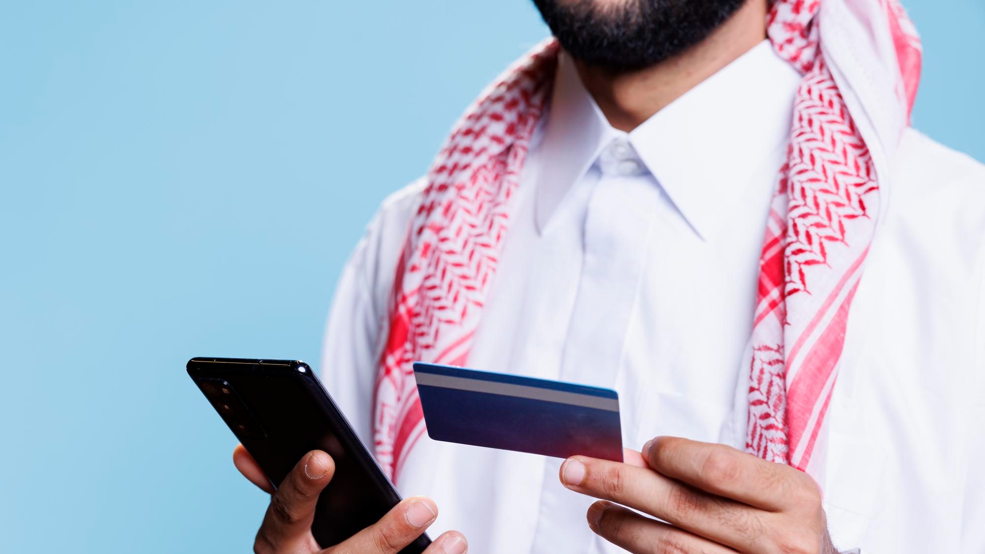 arab-hands-holding-credit-card-phone for ADIB