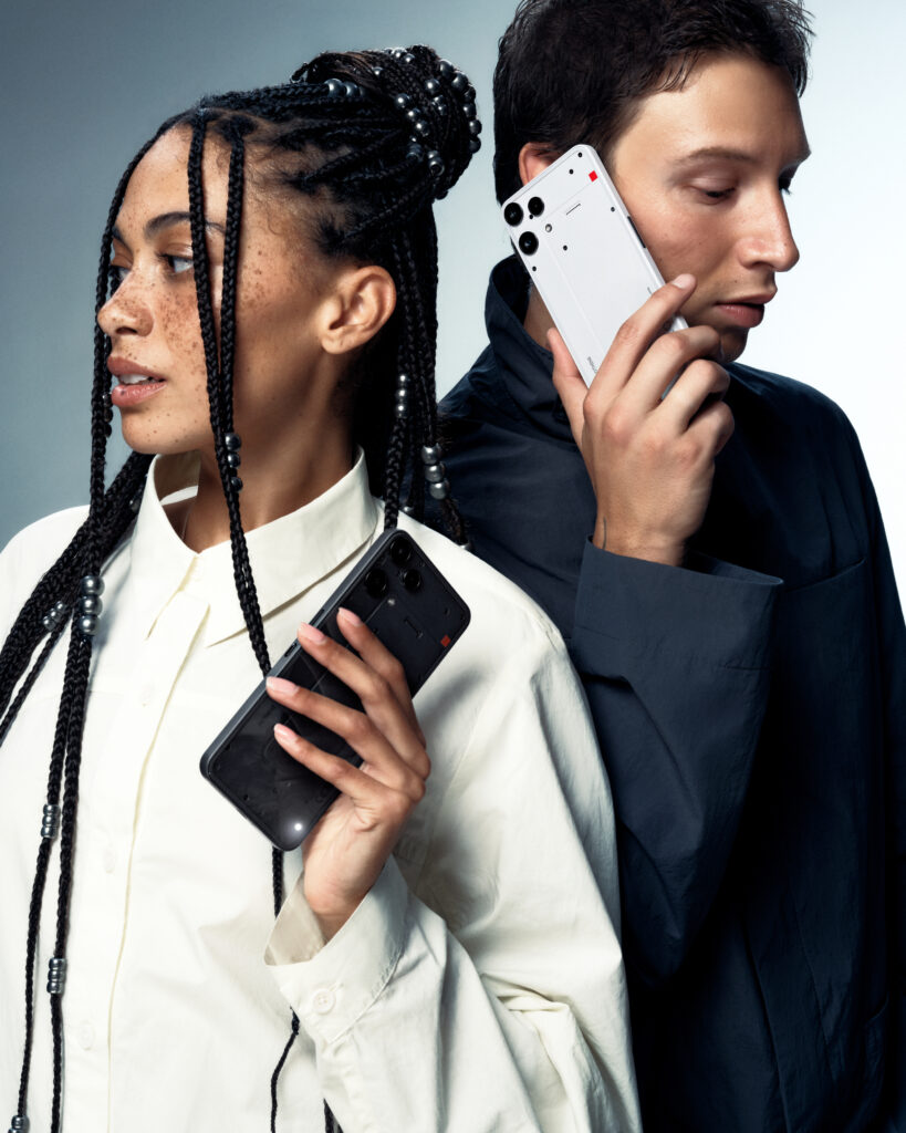 A vertical shot of two models holding the Nothing Phone (3a) Lite
