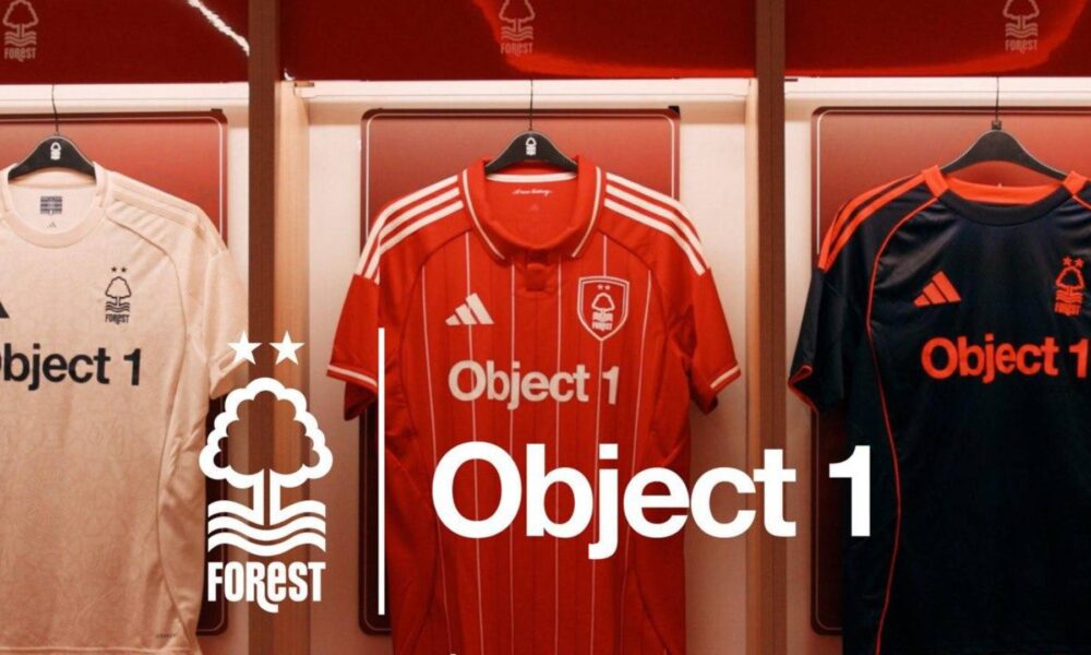 Object 1 branded Nottingham Forest football jerseys displayed on hangers - white away kit, red home kit, and black goalkeeper kit with Forest club logo