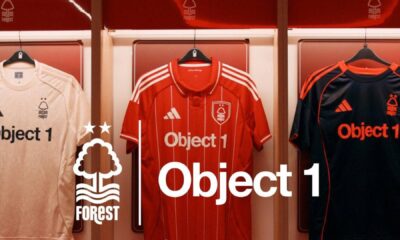 Object 1 branded Nottingham Forest football jerseys displayed on hangers - white away kit, red home kit, and black goalkeeper kit with Forest club logo