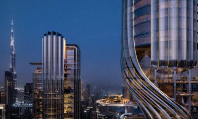 Architectural rendering of Object 1 premium high-rise residential development featuring distinctive curved metallic facade and sky terraces with Burj Khalifa visible in background during blue hour in Dubai