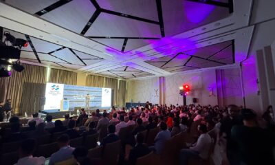 Large audience at Synology UAE Solution Day event with speaker presenting enterprise data protection solutions on stage with purple ambient lighting.