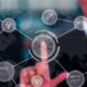 Business professional pointing at digital network interface with interconnected icons representing enterprise solutions, innovation, and global connectivity over world map background.