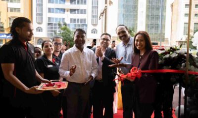 Ribbon-cutting ceremony with smiling guests and team members celebrating the opening event.