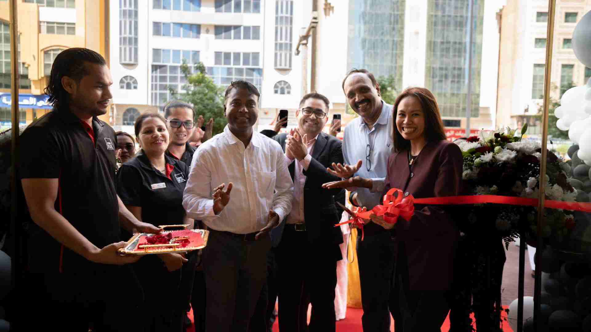 Ribbon-cutting ceremony with smiling guests and team members celebrating the opening event.
