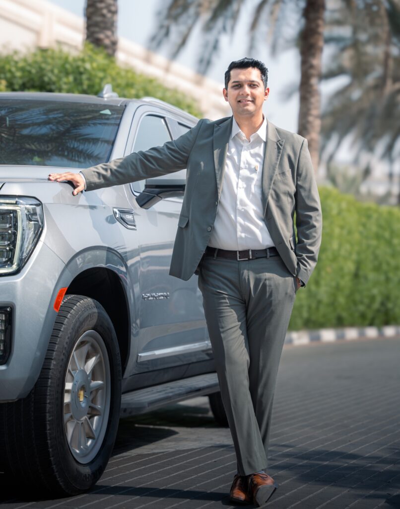 A front-angle shot of Harshvardhan Singh, Business Head, CARIVA standing beside a Chevy Tahoe
