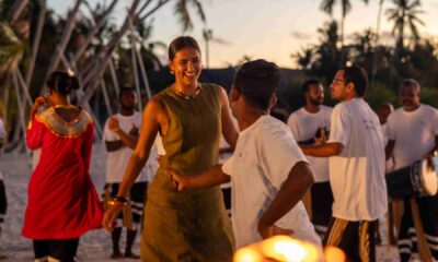 Guests dancing at sunset beach celebration with traditional Maldivian performers at Sun Siyam resort