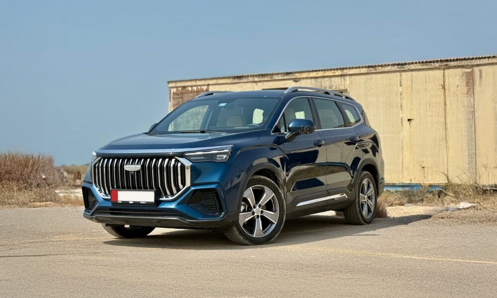 A front three-quarter shot of a blue Geely Okavango parked outdoors.