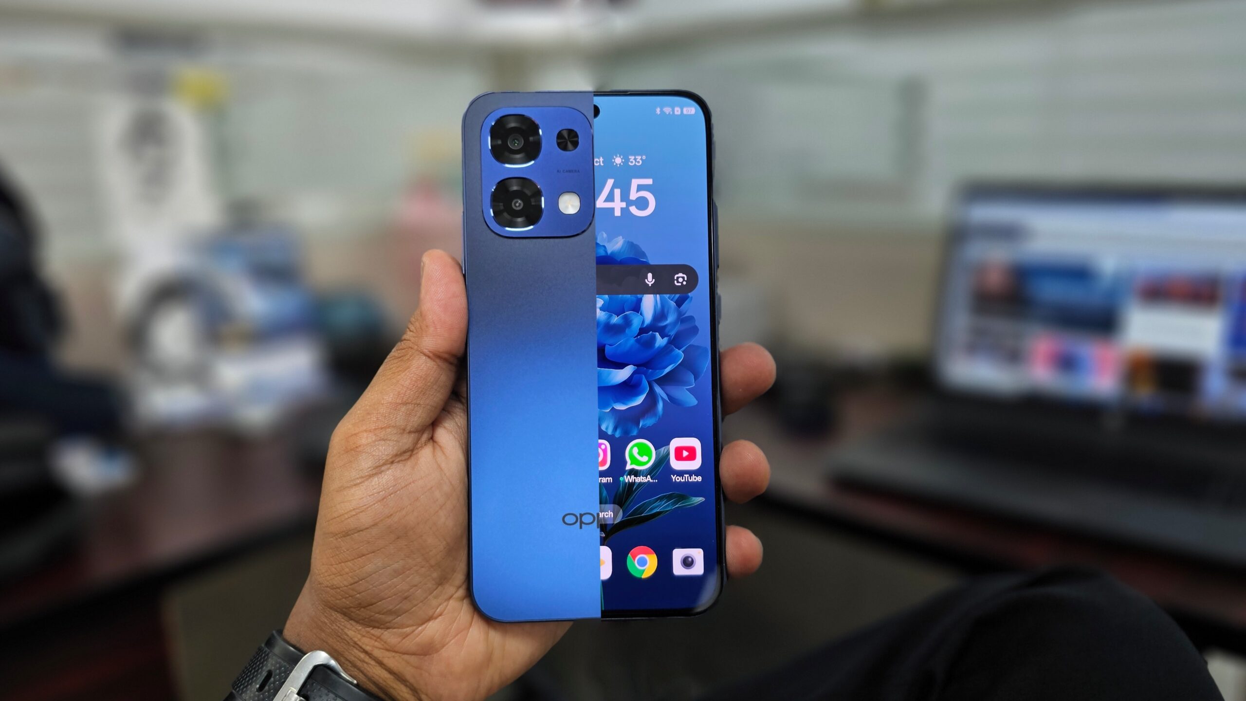 An combined shot of the front and back of a Blue Oppo A6 Pro 5G held in hand.