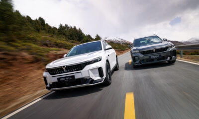 A front-angle action shot of two VOYAH FREE SUVs driven parallelly on a scenic road