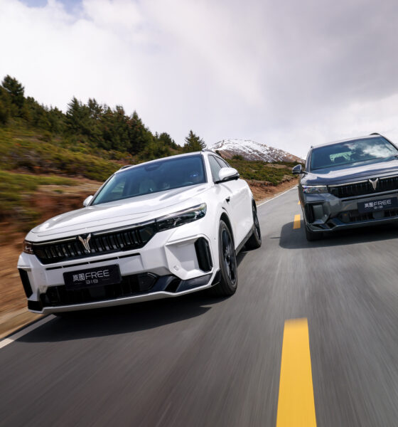 A front-angle action shot of two VOYAH FREE SUVs driven parallelly on a scenic road