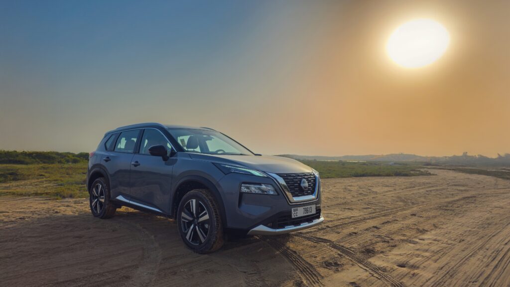 A front three-quarter shot of a Gray 2025 Nissan X-Trail parked outdoors in a desert.