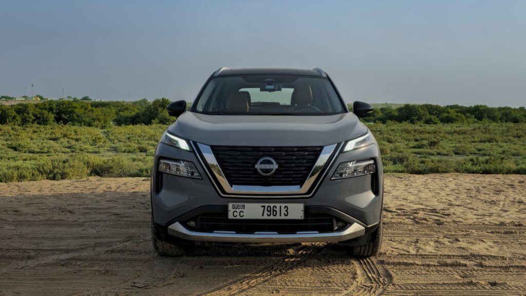 A front-angle shot of a Gray 2025 Nissan X-Trail parked outdoors in a desert.