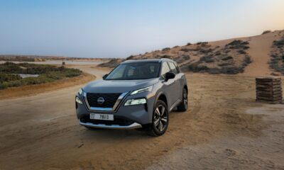 A front-angle three-quarter shot of a Gray 2025 Nissan X-Trail parked outdoors in a desert.