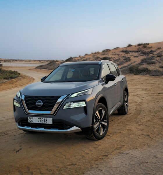A front-angle three-quarter shot of a Gray 2025 Nissan X-Trail parked outdoors in a desert.