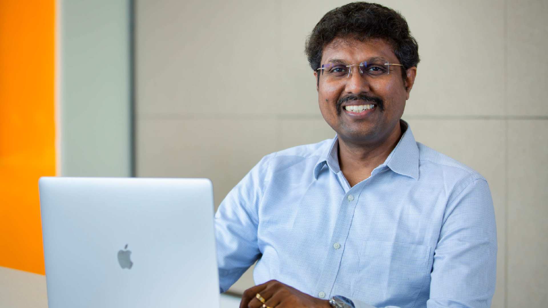 Alt Text: Manikandan Thangaraj, Vice President of ManageEngine, working at laptop in office setting