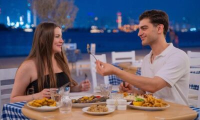 Couple dining at Bakalis Greek restaurant at Th8 Palm with waterfront views and Mediterranean cuisine