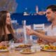 Couple dining at Bakalis Greek restaurant at Th8 Palm with waterfront views and Mediterranean cuisine