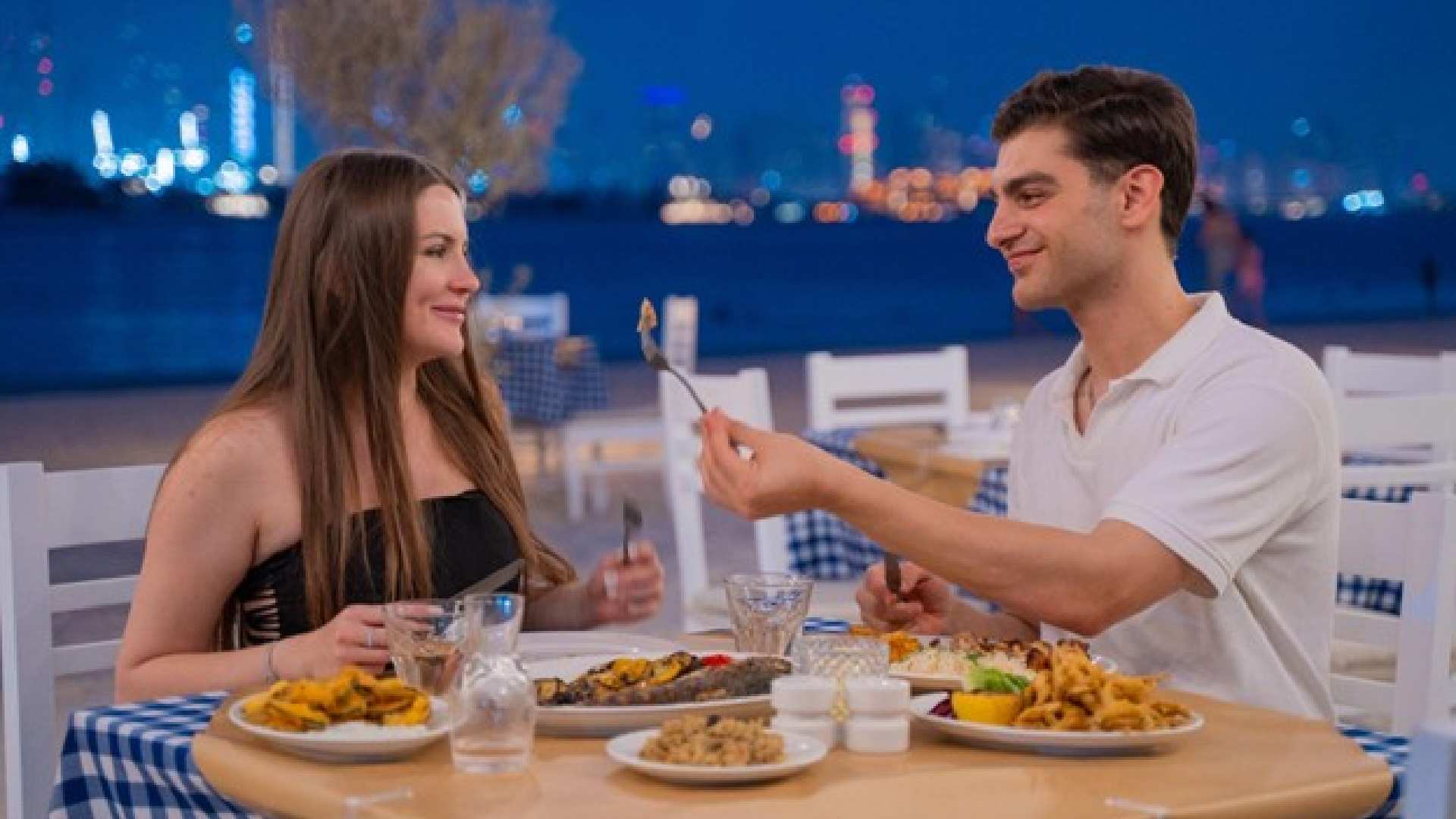Couple dining at Bakalis Greek restaurant at Th8 Palm with waterfront views and Mediterranean cuisine