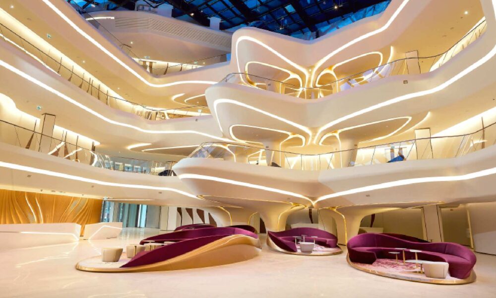 Luxury shopping mall interior with curved LED lighting, multi-level atrium, and purple velvet seating areas