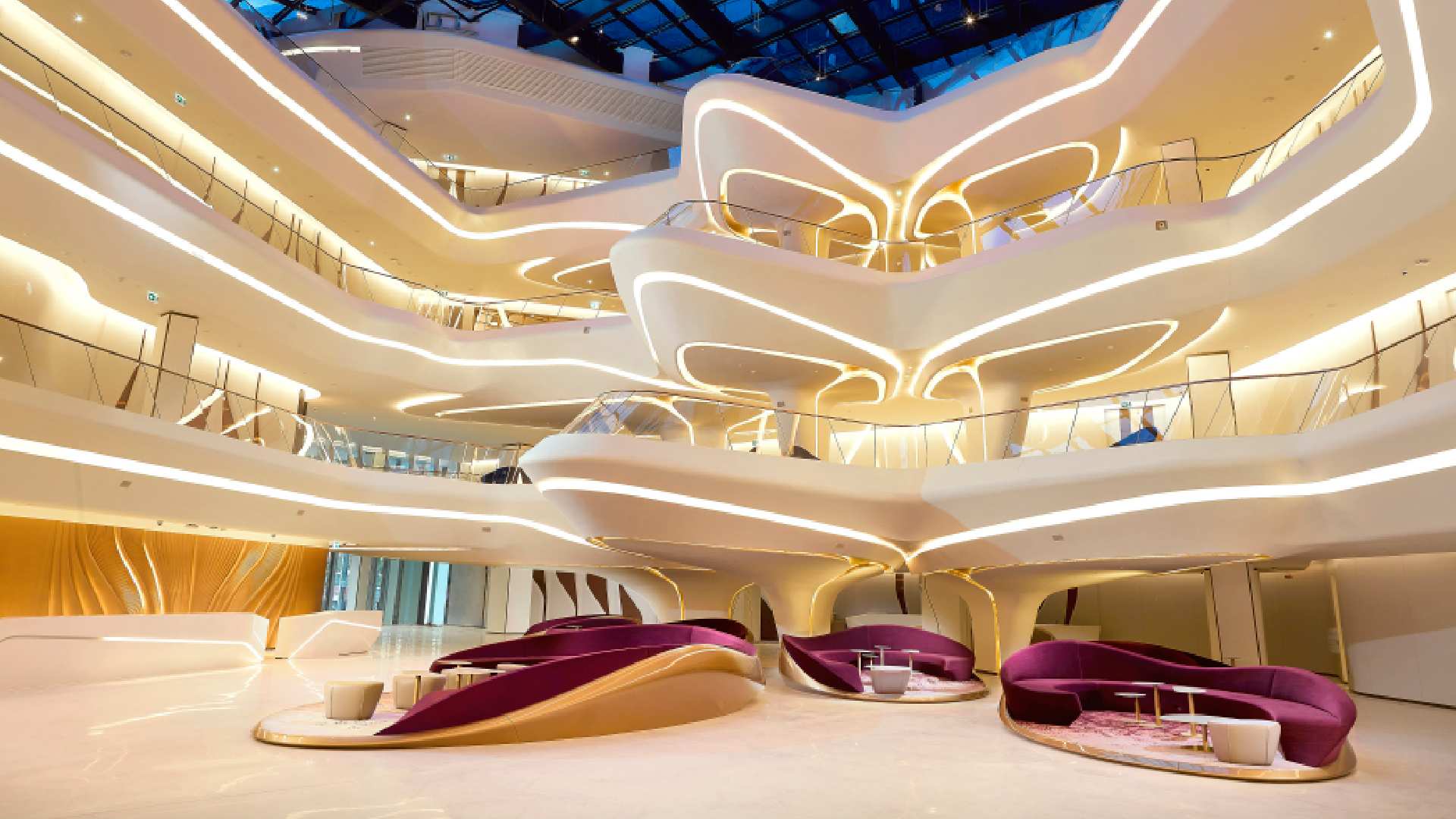 Luxury shopping mall interior with curved LED lighting, multi-level atrium, and purple velvet seating areas