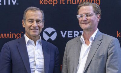 Two business executives at Vertiv press event with keep it humming branding