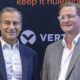 Two business executives at Vertiv press event with keep it humming branding