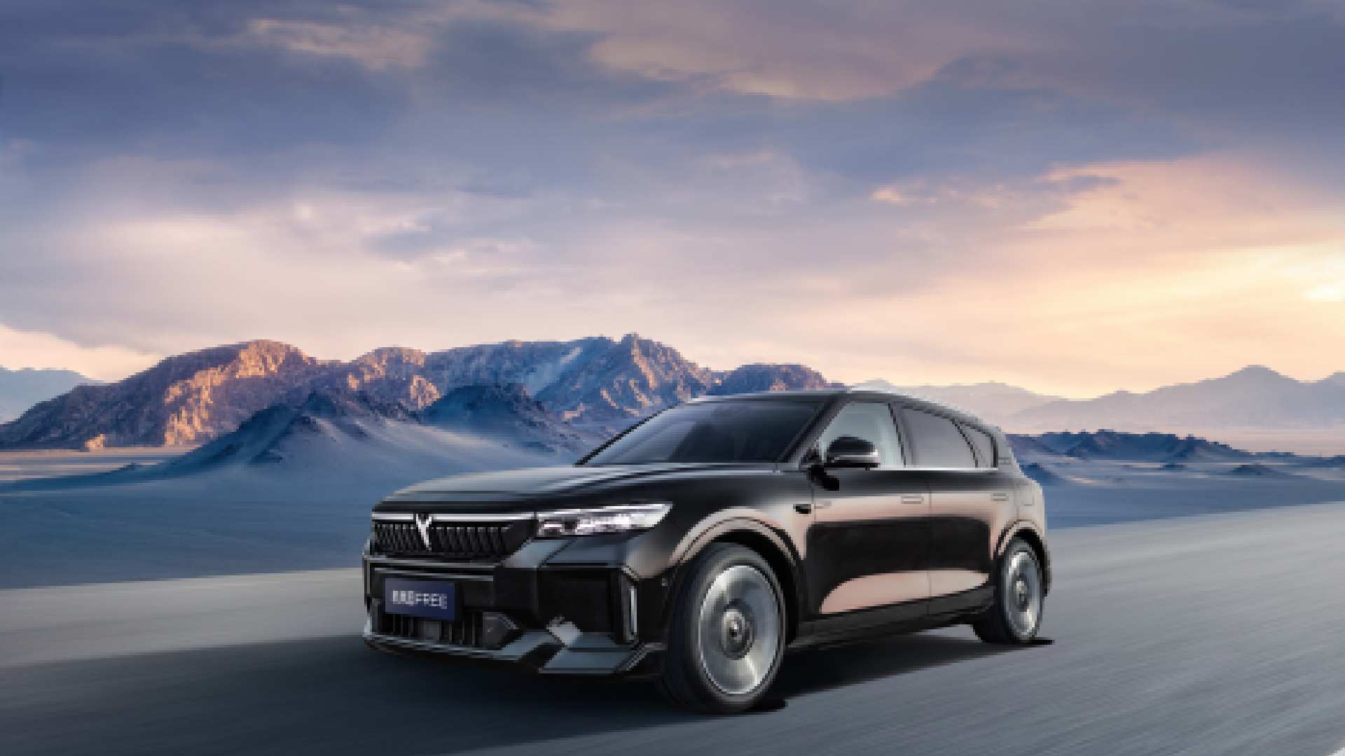 VOYAH Free electric SUV driving through desert landscape with mountains at sunset