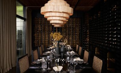 Elegant dining room at Sun Siyam Pasikudah with tiered woven chandelier, wicker chairs, and wine cellar wall