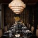 Elegant dining room at Sun Siyam Pasikudah with tiered woven chandelier, wicker chairs, and wine cellar wall