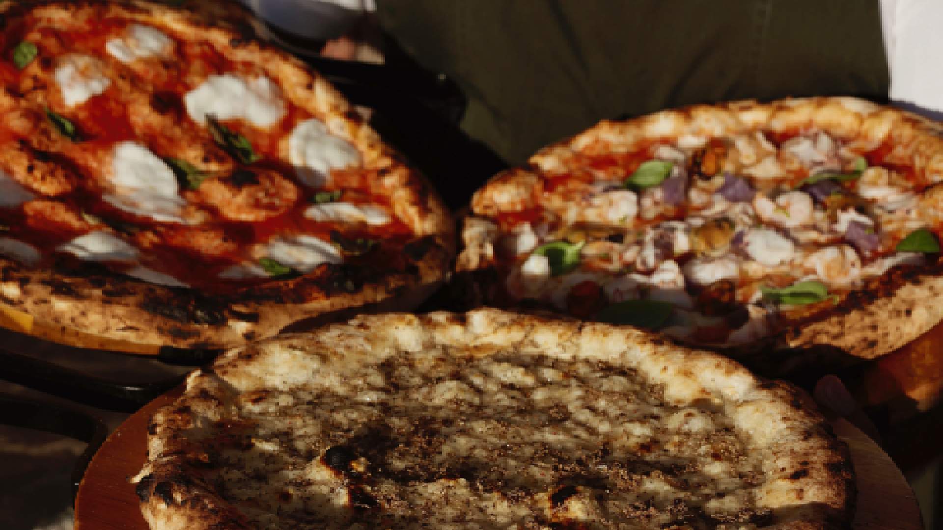 Wood-fired pizzas with fresh mozzarella and toppings at Acquasale by CUCINA Italian restaurant