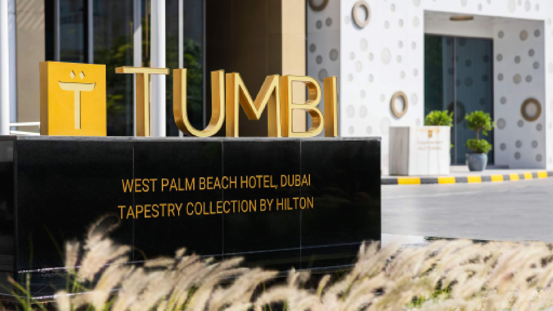 Tumbi restaurant golden signage at West Palm Beach Hotel Dubai, Tapestry Collection by Hilton entrance