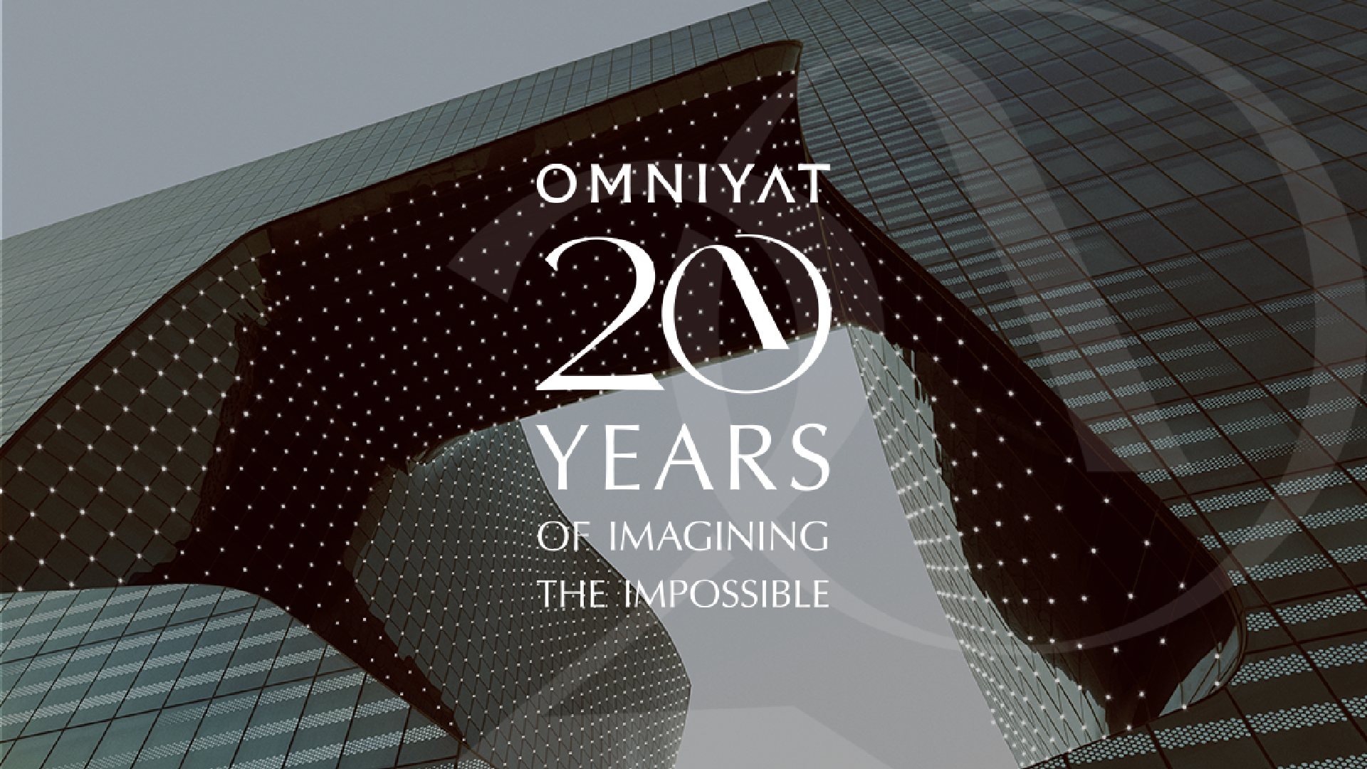 OMNIYAT 20 Years anniversary graphic overlaid on modern architectural building with illuminated facade featuring curved glass and geometric pattern