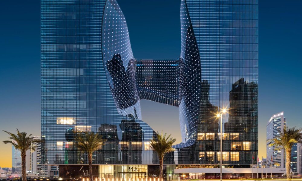 ME By Meliá Dubai Opus building illuminated at dusk with MICHELIN 2025 logo, showcasing Zaha Hadid's distinctive architectural design
