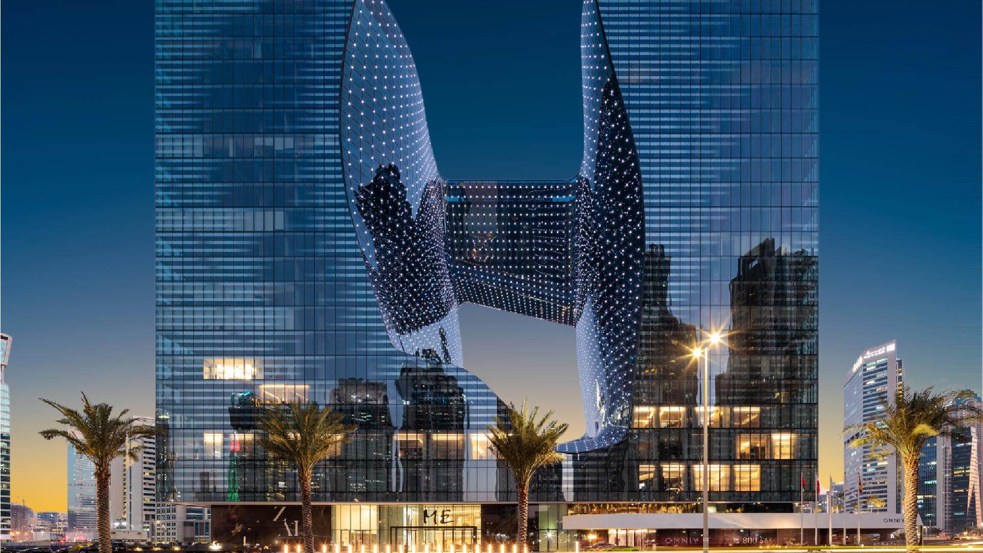ME By Meliá Dubai Opus building illuminated at dusk with MICHELIN 2025 logo, showcasing Zaha Hadid's distinctive architectural design