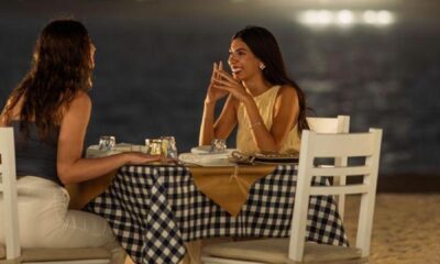 Two people sitting on the beach and resting and laughing and talking